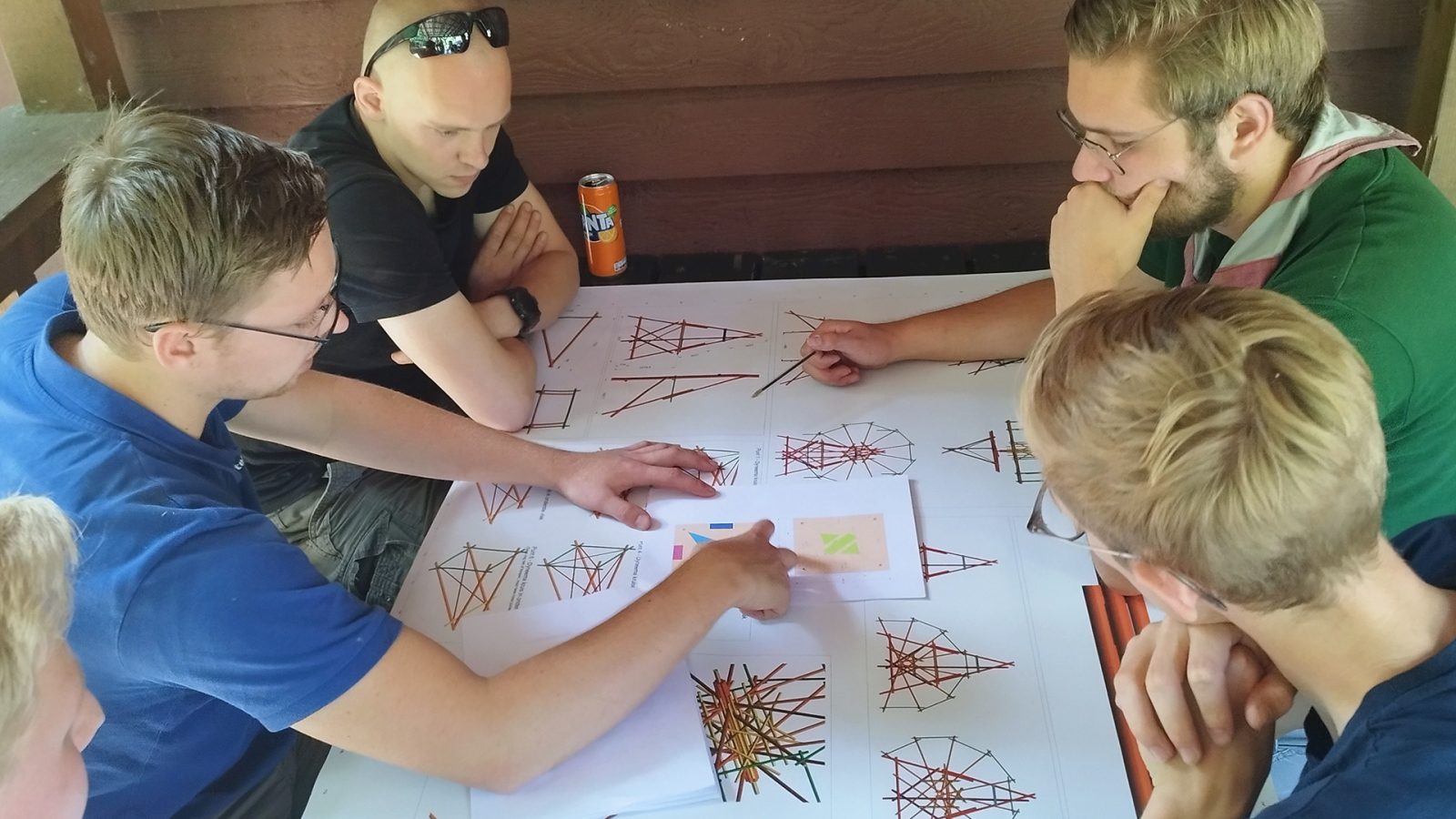 Jesse and his fellow pioneers discussing the lifting plan for constructing the Ferris wheel.