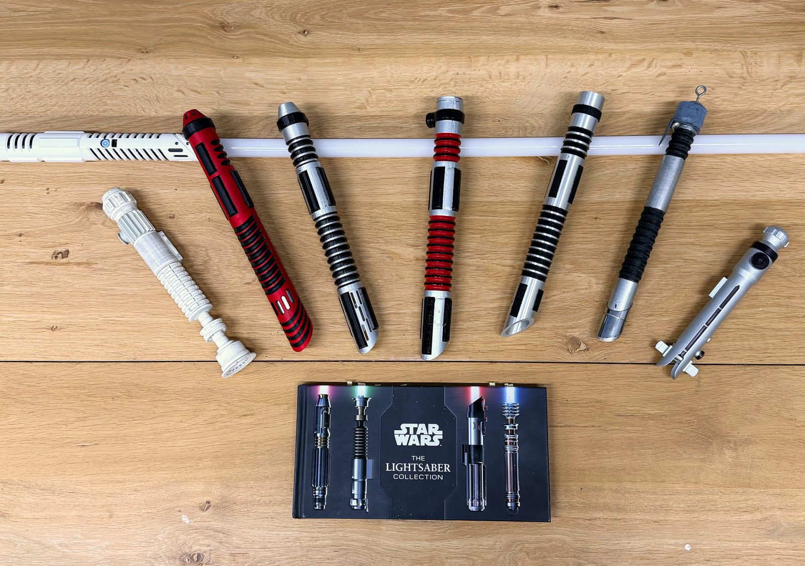 All of Pascal’s self-designed lightsabers lined up, alongside the official ‘Star Wars Lightsaber Collection’ book.